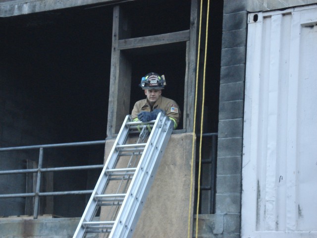 Firefighter Cedeno secures the ladder before the FAST team climbs down